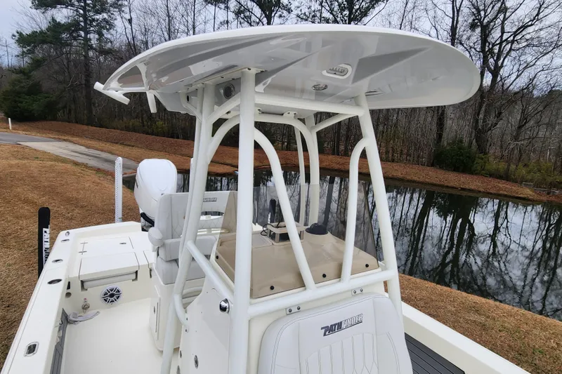 Slide: The Image of 2024 Pathfinder 2600 TRS boat with T-top, docked by a serene lake. - 16