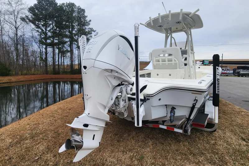 Slide: The Image of 2024 Pathfinder 2600 TRS boat with Yamaha outboard motor, parked near a pond. - 3