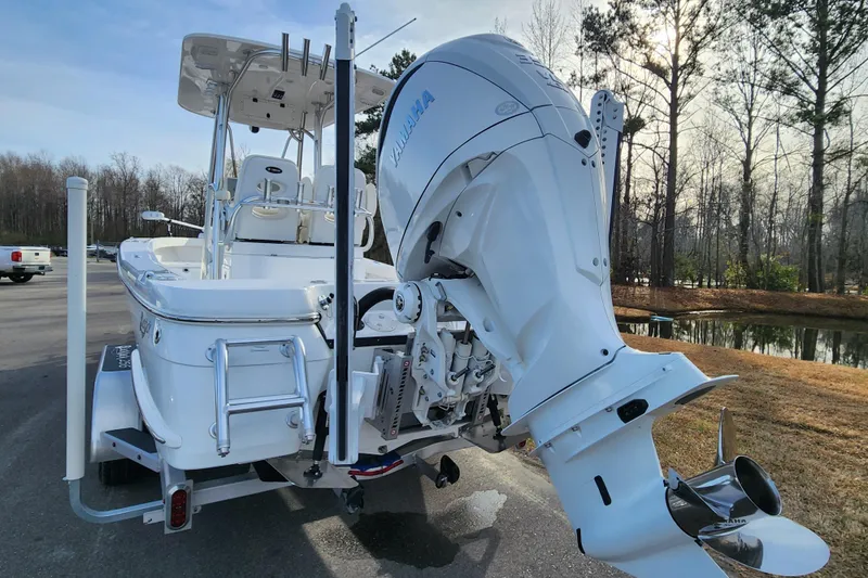Slide: The Image of 2025 BlackJack 256 Coastal boat with Yamaha outboard motor, parked near a wooded area. - 3