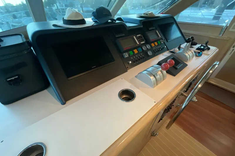 Slide: The Image of 1997 Hatteras 70 Sport Deck Motor Yacht helm with navigation controls and steering wheel. - 15