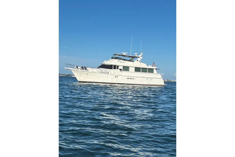 Slide: The Image of 1997 Hatteras 70 Sport Deck Motor Yacht on calm blue water under clear sky. - 49
