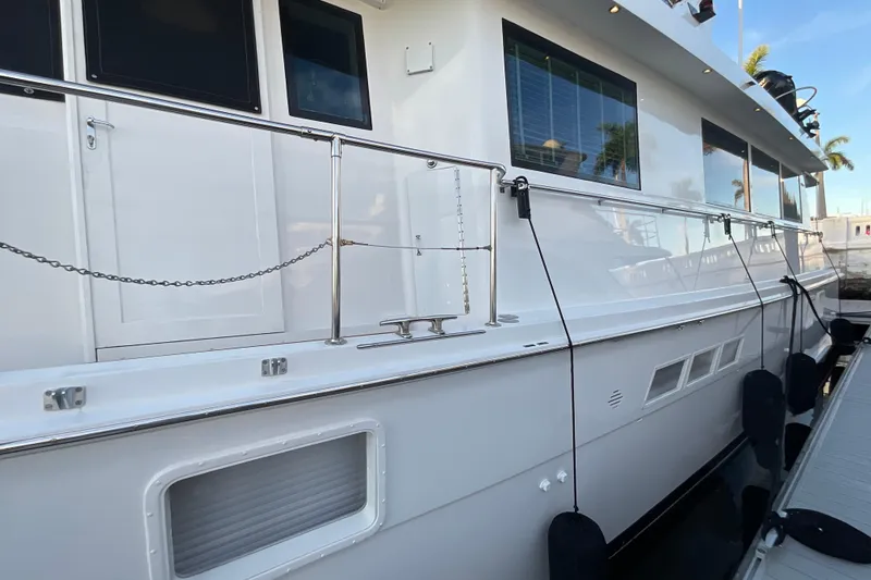Slide: The Image of 1997 Hatteras 70 Sport Deck Motor Yacht docked, showcasing sleek white exterior and modern design. - 5