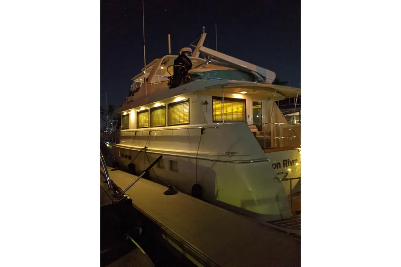 Slide: The Image of 1997 Hatteras 70 Sport Deck Motor Yacht docked at night, illuminated by soft lighting. - 50