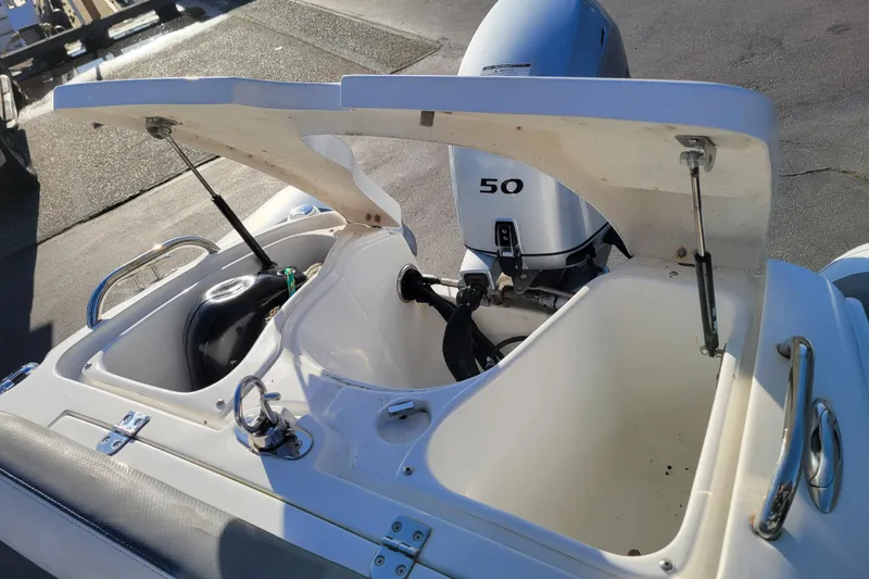 Slide: The Image of 2018 Walker Bay Generation 400 DLX boat with open storage compartments and 50 HP engine. - 18