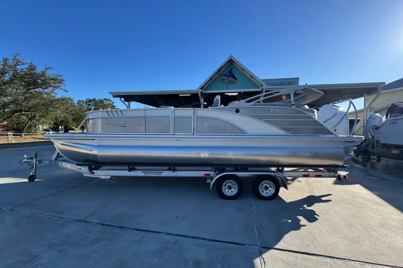 The Image of 2026 Bennington 23 LTFB pontoon boat on trailer, parked outdoors. - 1