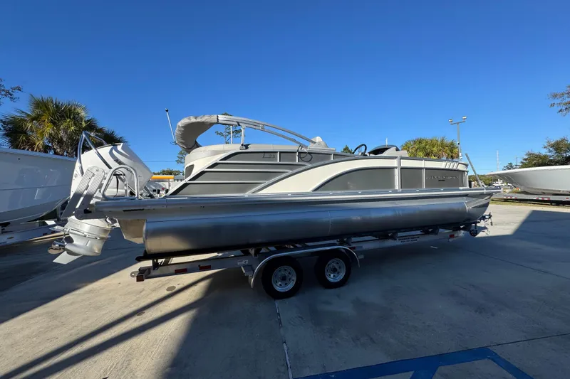 Slide: The Image of 2026 Bennington 23 LTFB pontoon boat on trailer under clear blue sky. - 10