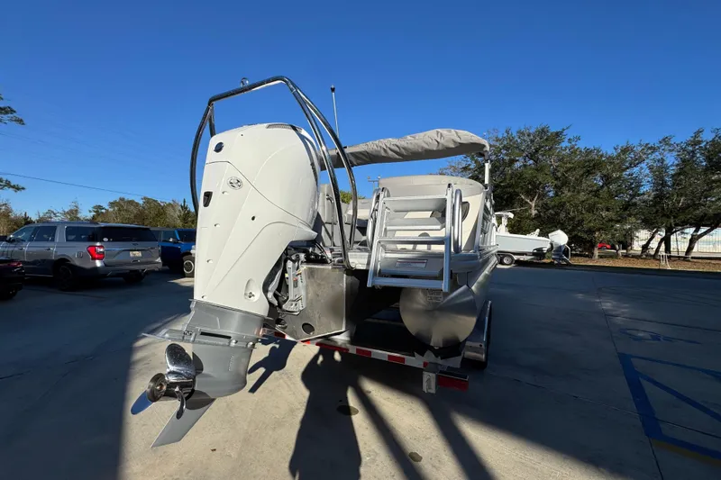 Slide: The Image of 2026 Bennington 23 LTFB pontoon boat with outboard motor, parked outdoors. - 12