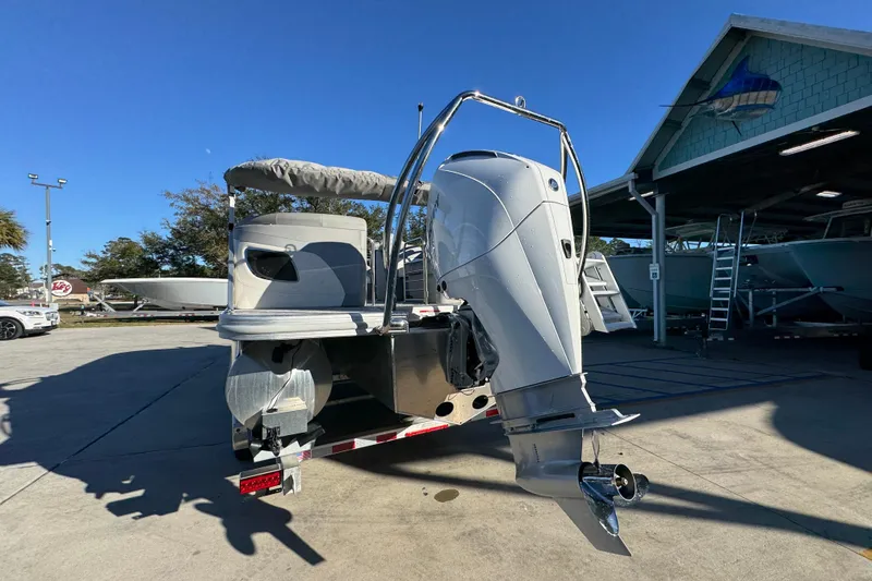 Slide: The Image of 2026 Bennington 23 LTFB boat with outboard motor in a sunny marina setting. - 14