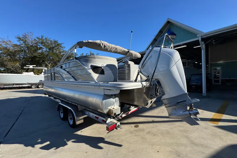 Slide: The Image of 2026 Bennington 23 LTFB pontoon boat with Mercury outboard motor on trailer. - 15
