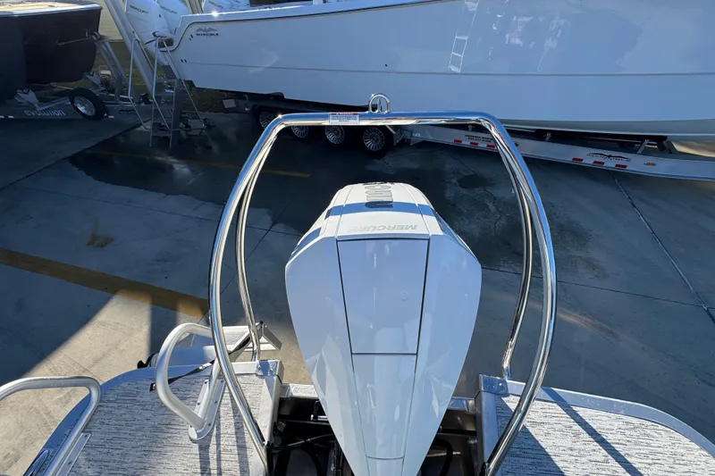 Slide: The Image of 2026 Bennington 23 LTFB boat with Mercury outboard motor, docked on a trailer. - 35