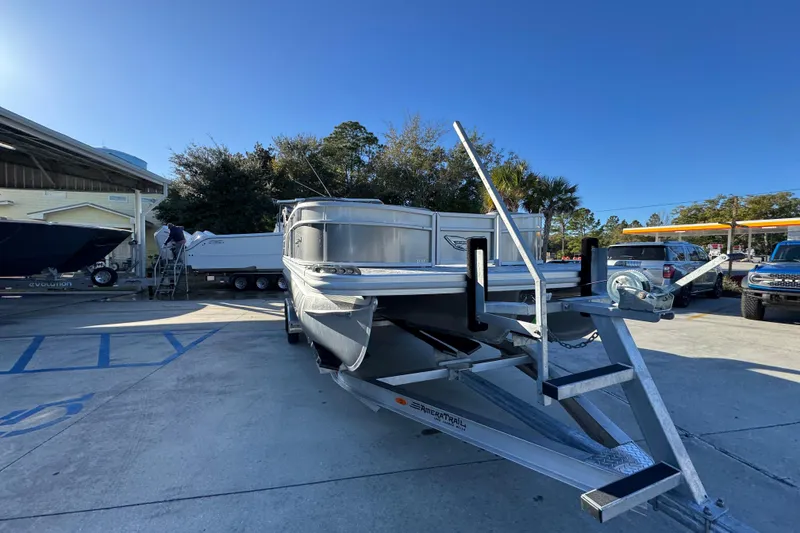 Slide: The Image of 2026 Bennington 23 LTFB pontoon boat on trailer in sunny outdoor setting. - 6