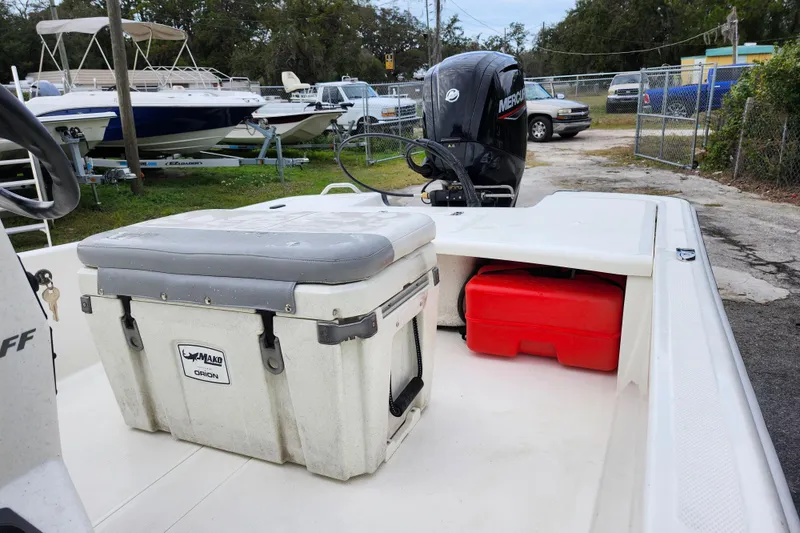Slide: The Image of 2024 Mako Pro Skiff 17 CC boat with Mercury engine and storage compartments. - 12