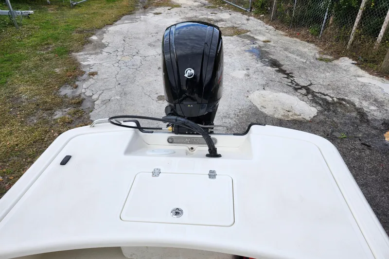 Slide: The Image of 2024 Mako Pro Skiff 17 CC boat with outboard motor on a cracked pavement. - 13