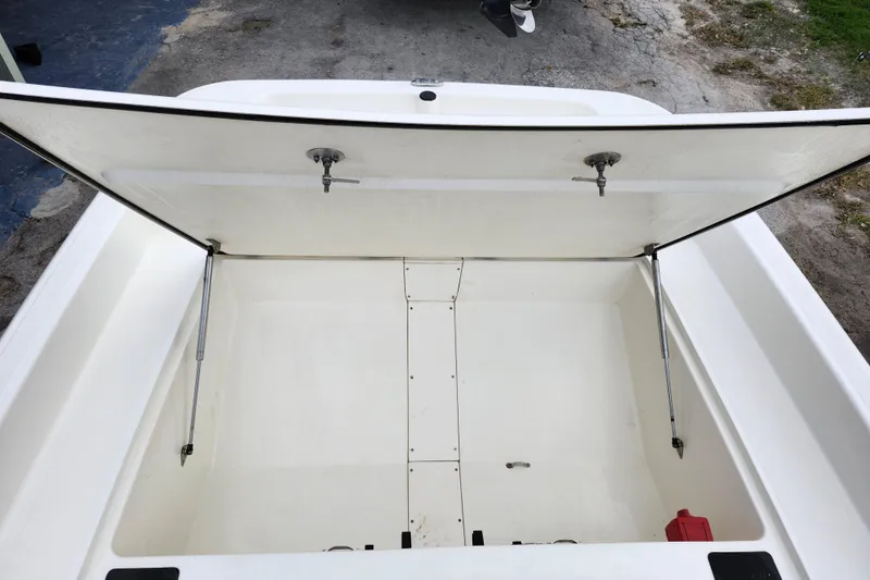 Slide: The Image of 2024 Mako Pro Skiff 17 CC storage compartment open, showcasing spacious interior. - 15