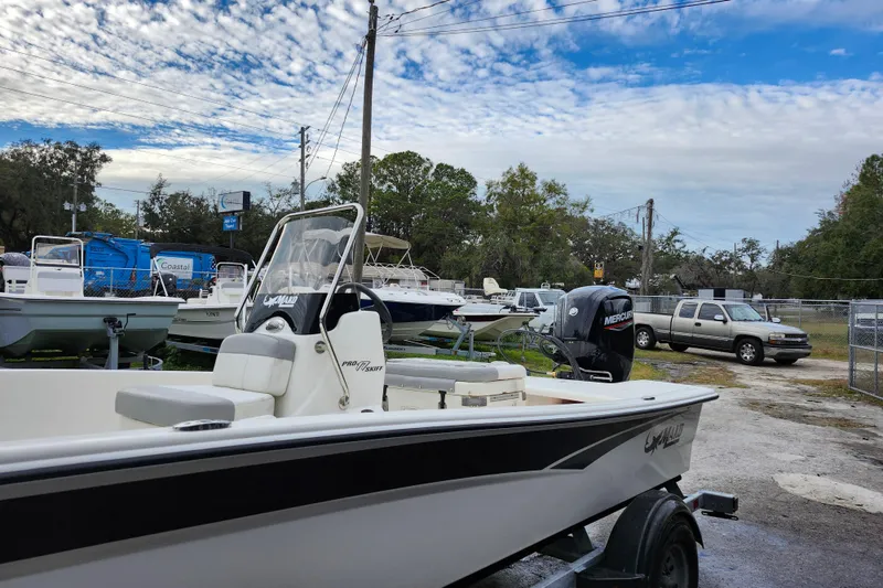 Slide: The Image of 2024 Mako Pro Skiff 17 CC boat on trailer in outdoor dealership lot. - 3