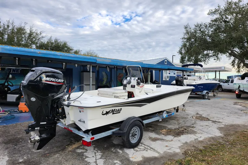 Slide: The Image of 2024 Mako Pro Skiff 17 CC boat on trailer, parked outdoors near dealership. - 6