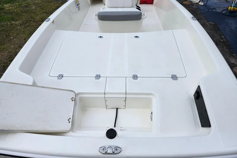 Slide: The Image of 2024 Mako Pro Skiff 17 CC boat interior with storage compartments open. - 9