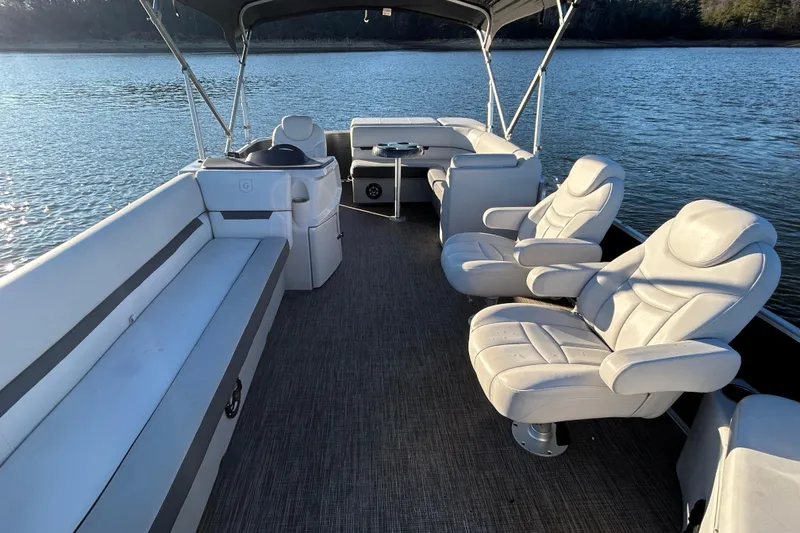 Slide: The Image of 2023 Godfrey Sweetwater 2286 C pontoon boat interior with plush seating on a serene lake. - 10