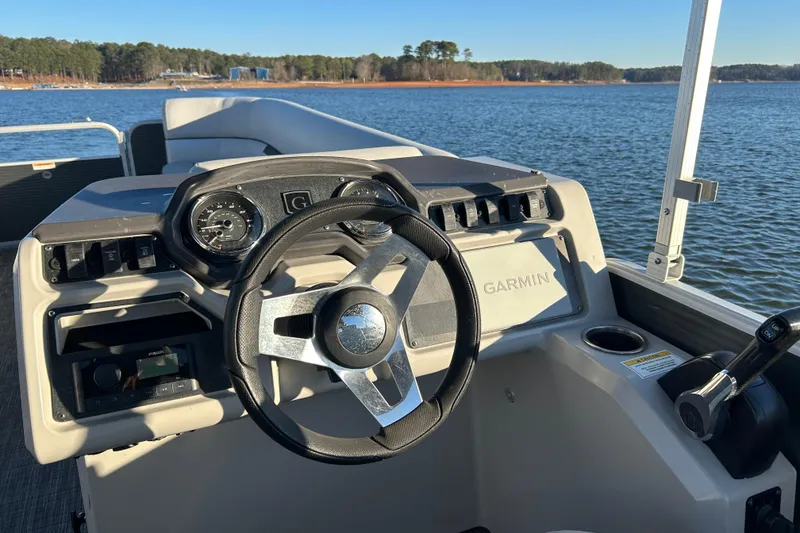 Slide: The Image of 2023 Godfrey Sweetwater 2286 C boat dashboard with Garmin navigation on a lake. - 11