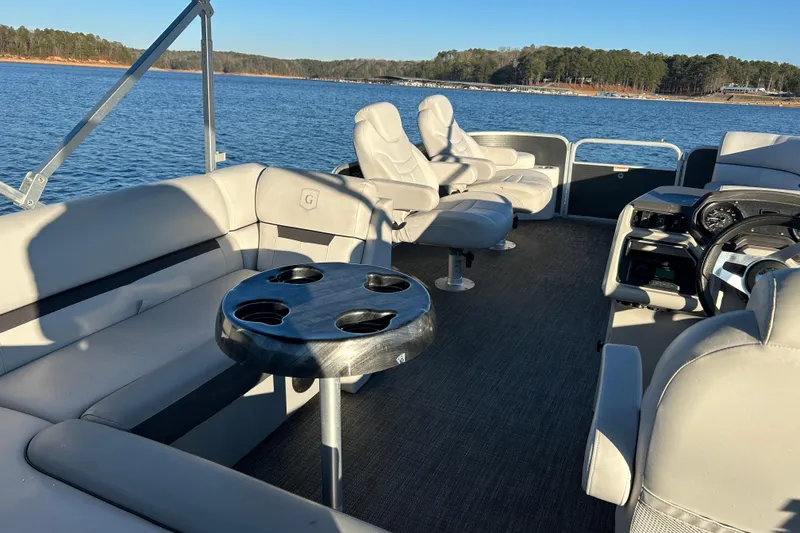 Slide: The Image of 2023 Godfrey Sweetwater 2286 C pontoon boat interior with seating and cup holders on a lake. - 16