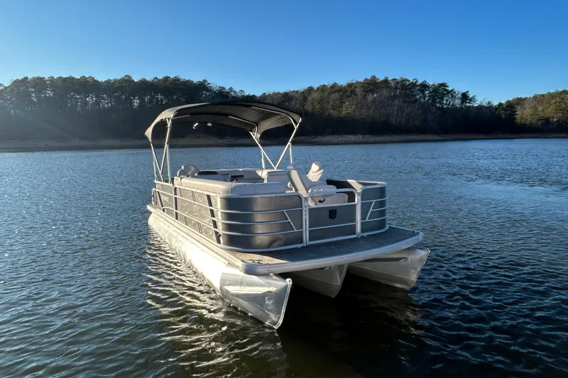 Slide: The Image of 2023 Godfrey Sweetwater 2286 C pontoon boat on a serene lake. - 4