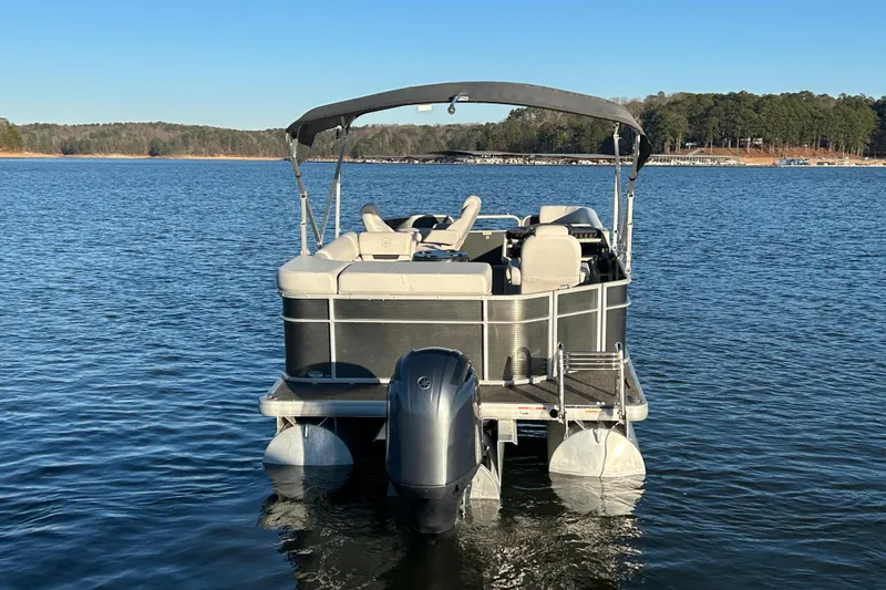 Slide: The Image of 2023 Godfrey Sweetwater 2286 C pontoon boat on a serene lake. - 7