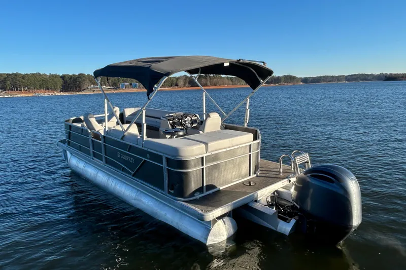 Slide: The Image of 2023 Godfrey Sweetwater 2286 C pontoon boat on a serene lake. - 8