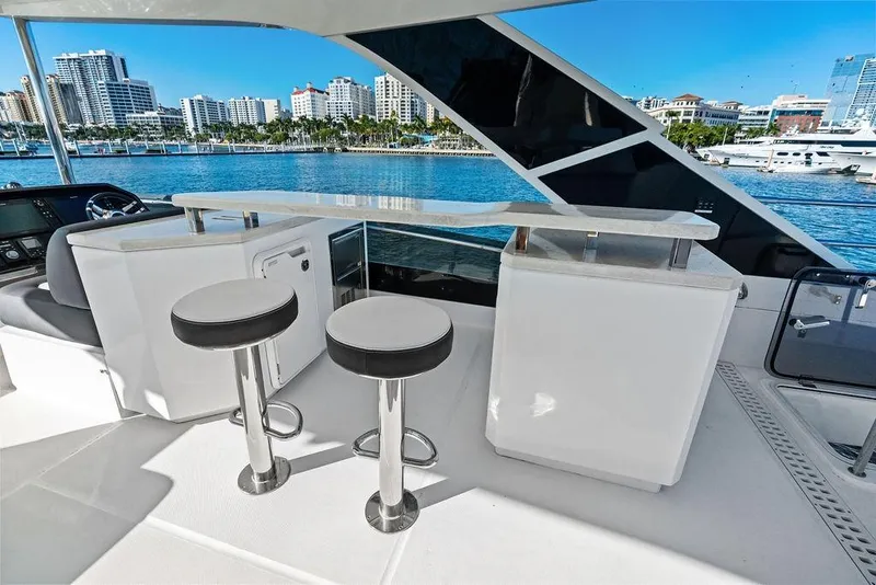 Slide: The Image of 2018 Galeon 640 Fly yacht interior with bar stools and waterfront city view. - 32