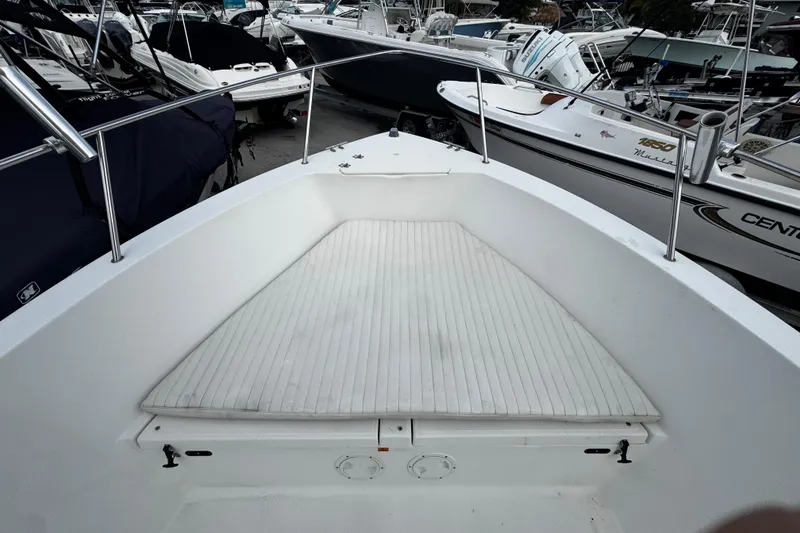 Slide: The Image of 2023 Hydra-Sports 212 CC boat interior with cushioned seating, docked among other boats. - 14