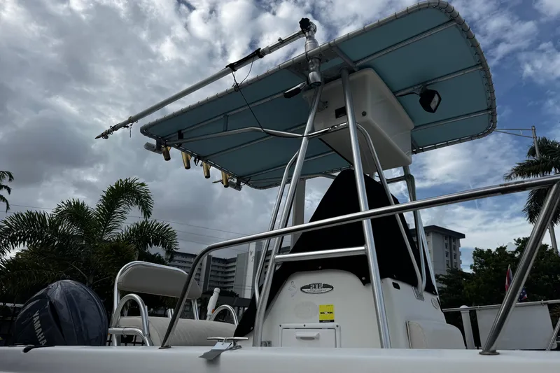 Slide: The Image of 2023 Hydra-Sports 212 CC boat with T-top, under cloudy sky, palm trees in background. - 3