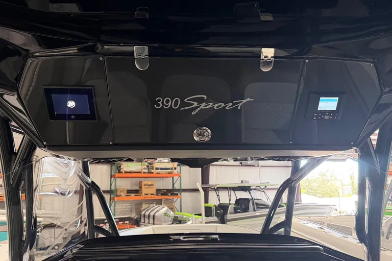 Slide: The Image of 2025 Nor-Tech 390 Sport Center Console dashboard with digital displays in a showroom. - 12