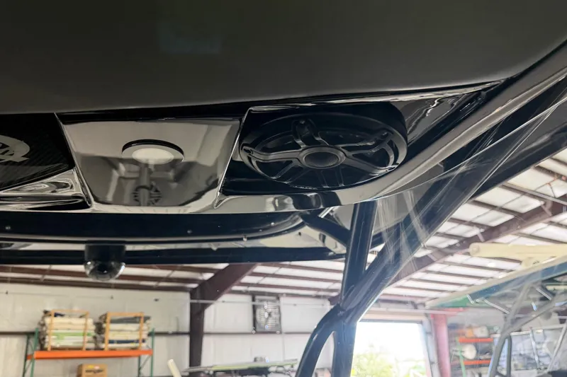 Slide: The Image of 2025 Nor-Tech 390 Sport Center Console speaker system in a boat garage. - 16