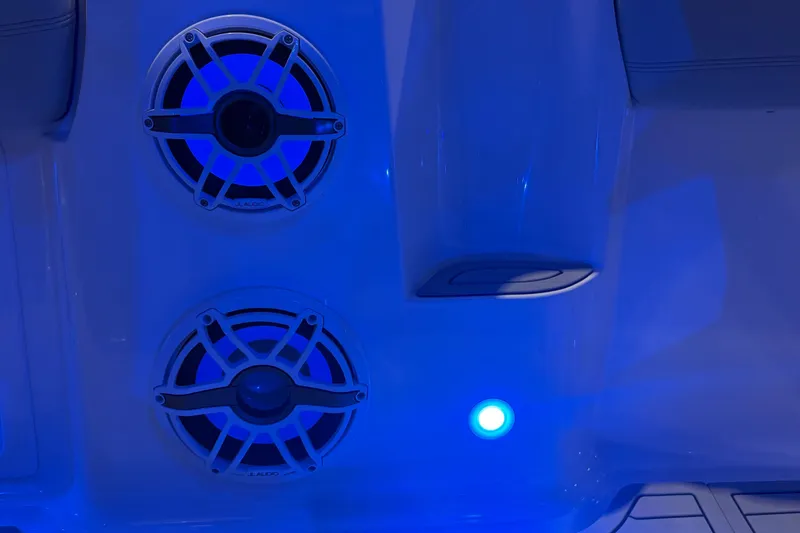 Slide: The Image of Blue-lit speakers on 2025 Nor-Tech 390 Sport Center Console boat interior. - 26