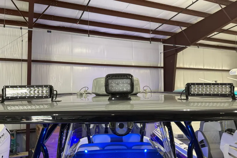 Slide: The Image of 2025 Nor-Tech 390 Sport Center Console with LED lights in a warehouse setting. - 33