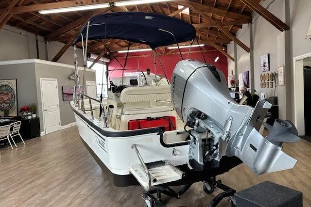 Slide: The Image of 2003 Boston Whaler 170 Montauk boat displayed indoors with outboard motor. - 11