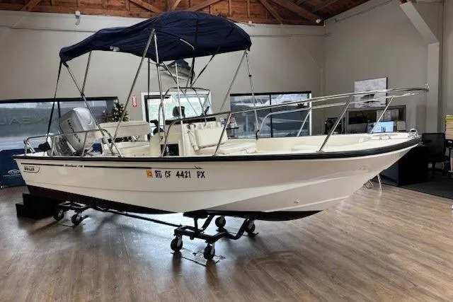 Slide: The Image of 2003 Boston Whaler 170 Montauk boat with canopy displayed indoors on a trailer. - 5