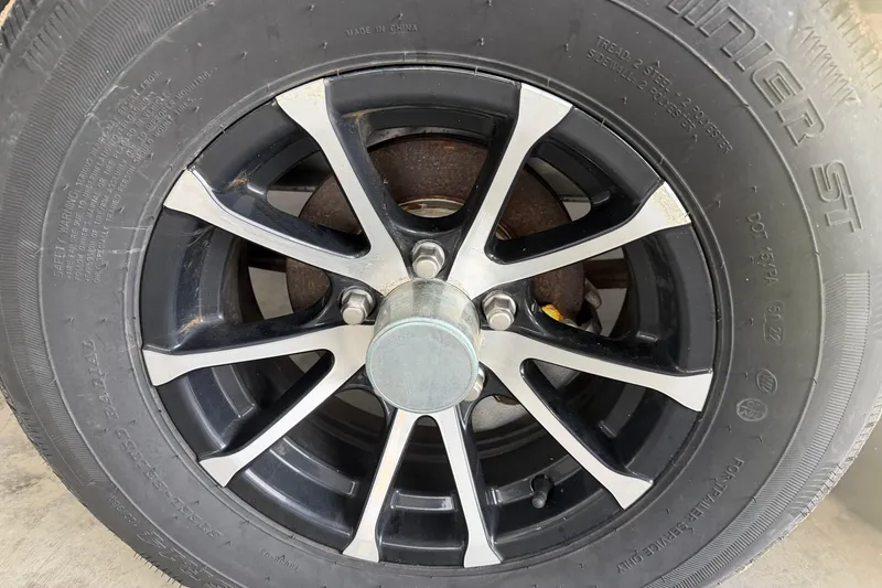 Slide: The Image of Close-up of a 2023 Aloha Pontoon PS 260 TT wheel with black and silver alloy rim. - 10