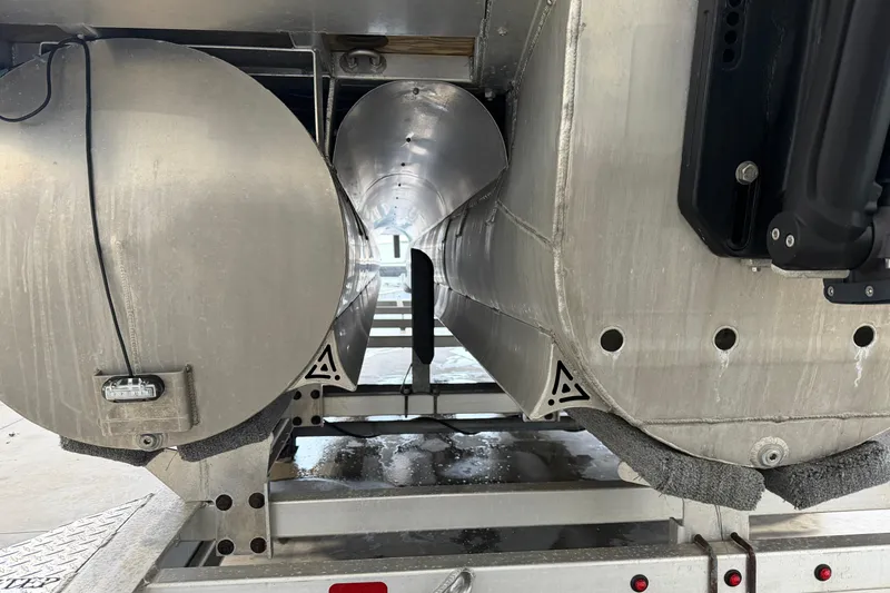 Slide: The Image of 2023 Aloha Pontoon PS 260 TT undercarriage view, showcasing aluminum pontoons and trailer. - 100