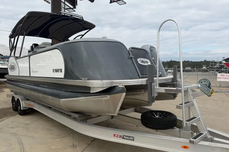 Slide: The Image of 2023 Aloha Pontoon PS 260 TT on trailer, featuring sleek design and dual engines. - 108