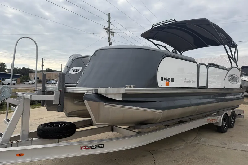 Slide: The Image of 2023 Aloha Pontoon PS 260 TT on trailer, sleek design, overcast sky. - 109