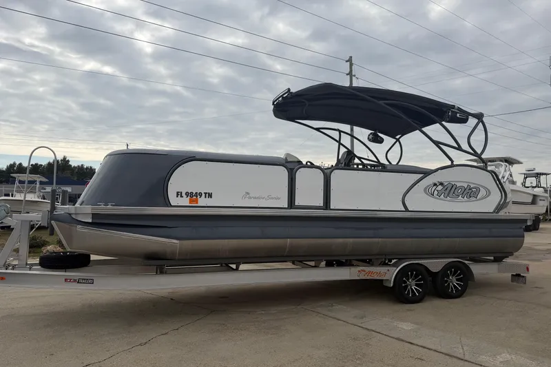 Slide: The Image of 2023 Aloha Pontoon PS 260 TT on trailer, featuring sleek design and canopy. - 110