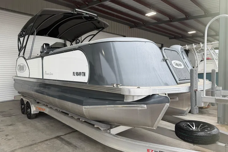 Slide: The Image of 2023 Aloha Pontoon PS 260 TT boat on trailer in covered storage area. - 12
