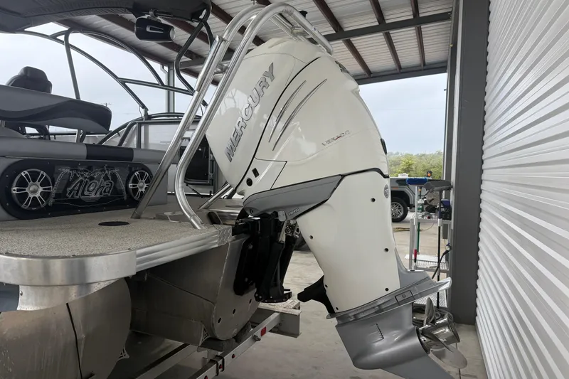 Slide: The Image of 2023 Aloha Pontoon PS 260 TT with Mercury outboard motor in a covered dock. - 2
