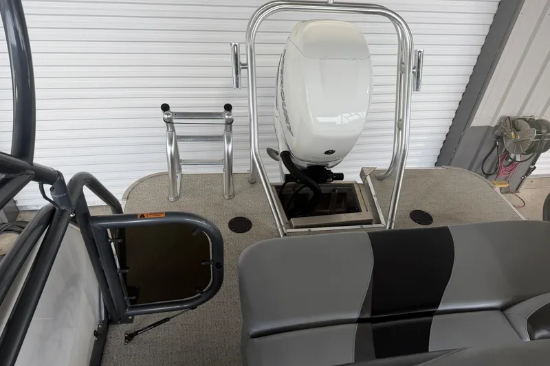 Slide: The Image of 2023 Aloha Pontoon PS 260 TT with outboard motor and swim ladder in a garage. - 29