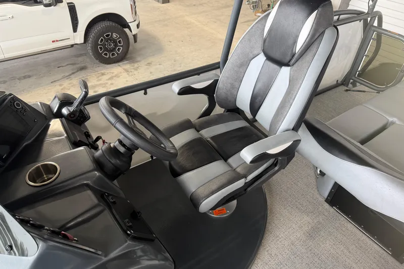 Slide: The Image of 2023 Aloha Pontoon PS 260 TT interior with steering wheel and captain's chair. - 35