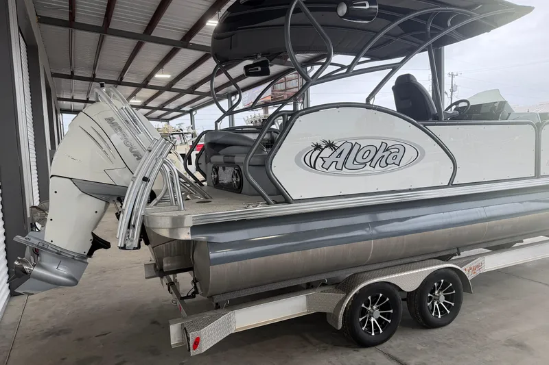 Slide: The Image of 2023 Aloha Pontoon PS 260 TT on trailer, featuring a Mercury outboard motor. - 4