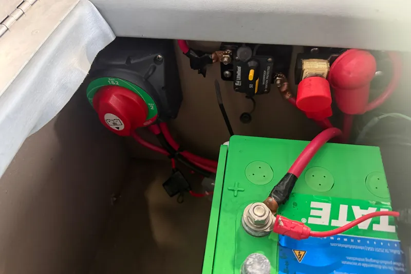 Slide: The Image of Battery compartment of 2023 Aloha Pontoon PS 260 TT with wiring and switch. - 41