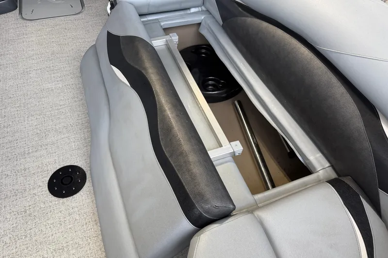 Slide: The Image of 2023 Aloha Pontoon PS 260 TT storage compartment with open seat revealing interior space. - 61