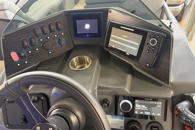Slide: The Image of 2023 Aloha Pontoon PS 260 TT dashboard with steering wheel, controls, and navigation system. - 75