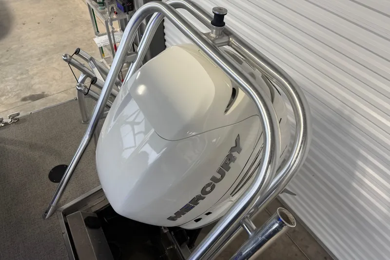 Slide: The Image of 2023 Aloha Pontoon PS 260 TT with Mercury outboard motor in a garage setting. - 87